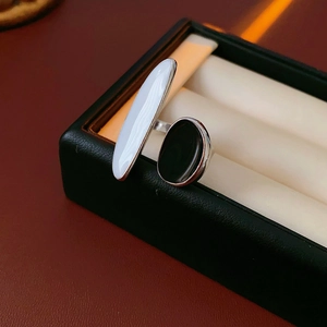 Macro view of geometric silver ring with black and white enamel in a jewelry box