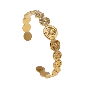 Vintage gold stainless steel open bangle featuring engraved sunburst geometric medallions