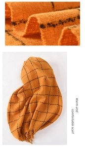 Close-up of orange and black plaid scarf texture and fringe detail on warm fabric