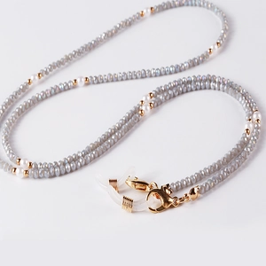 Detailed view of crystal beaded eyewear chain with pearls and gold lobster clasps