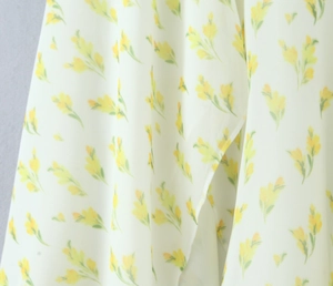 Dettaglio del tessuto in chiffon a fiori leggeri con stampe gialle e texture morbida