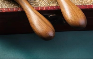 Detailed close-up of dark sandalwood hairbrush handle featuring natural wood grain texture