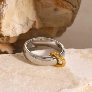 Dettaglio dell'anello bicolore in acciaio inossidabile argento e oro su pietra naturale