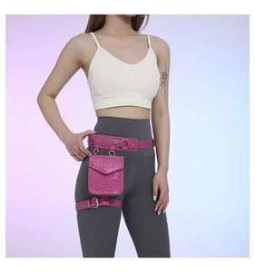Détail du sac de cuisse rose en similicuir à texture crocodile et boucles argentées