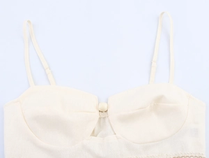 Detail of beige camisole top with textured fabric, adjustable straps and decorative button