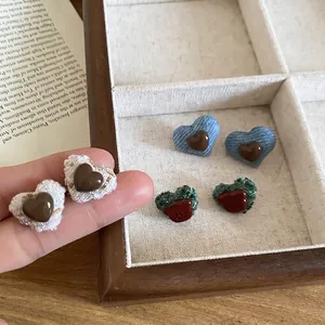 Elegant tweed and denim heart stud earrings set in a vintage wooden jewelry display box