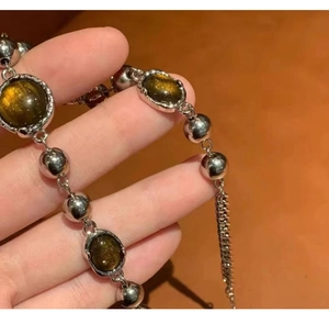 Detailed shot of retro silver beaded bracelet with oval dark green crystals on hand