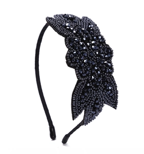 Close-up of bohemian headband featuring intricate black handmade beaded flower embroidery