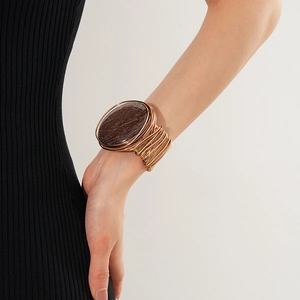 Detail of vintage bronze wire-wrapped cuff bracelet featuring a brown resin stone