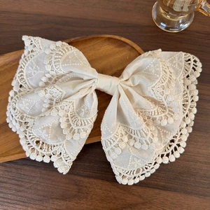 Detailed embroidery and lace hollow patterns on a beige bow hair clip for women