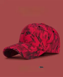 Détail d'une casquette de baseball graffiti rouge avec imprimé lettres noires et couture