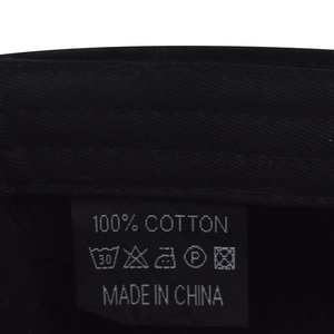 Détail de l'étiquette 100 % coton et des coutures sur une casquette délavée