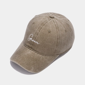 Detail of washed cotton baseball cap with white Groom script embroidery on khaki fabric