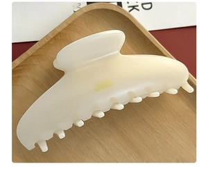 Close-up of creamy white matte acetate hair claw clip with gold Beautiful Life text
