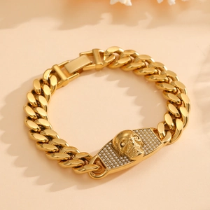Macro detail of golden Cuban link bracelet featuring a skull charm with micro-pave diamonds