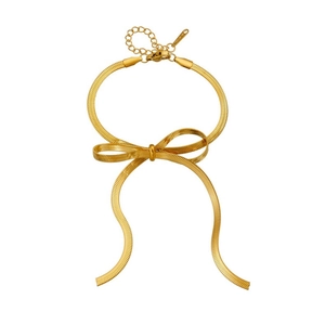 Detail of gold-plated stainless steel snake chain bracelet with elegant bow design