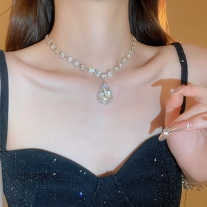 Close-up of sparkling waterdrop pendant necklace with rhinestones on model neck
