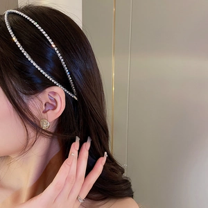 Close-up of a delicate silver rhinestone chain headband worn by a female model