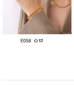 Detail of chunky gold chain necklace and bracelet paired with a beige blazer suit