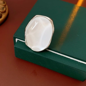 Detail of minimalist oval resin ring with white stone on a vintage jewelry box