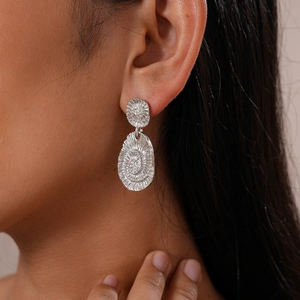 Gros plan détaillé de boucles d'oreilles argentées géométriques sur un mannequin