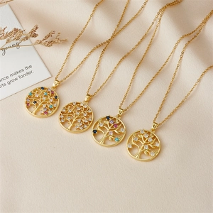 Golden Tree of Life necklaces with colorful zircon pendants on white textured fabric