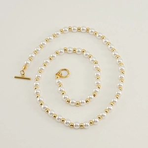 Close-up of 18k gold plated chain with white pearls and a stylish toggle clasp