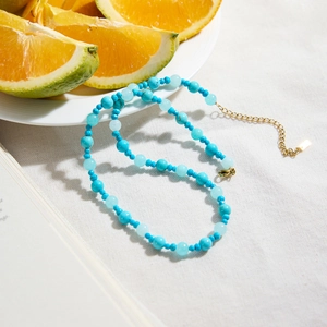 Classic 18K gold-plated stainless steel necklace with turquoise beads on linen fabric
