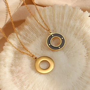 Detailed macro view of gold-tone circle pendants on refined O-chains with starburst pattern