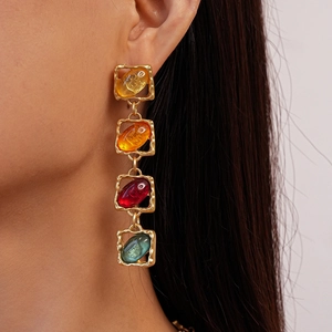 Detailed view of colorful resin tassel earrings on a model with gold metal frames