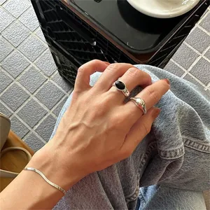 Detail of 925 sterling silver ring featuring a black agate stone on a hand model