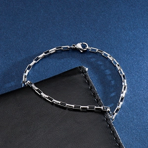 Detailed close-up of a silver stainless steel square link chain bracelet with lobster clasp