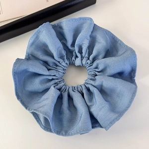 Close-up of blue double-layer fabric pleated scrunchie hair tie on white background