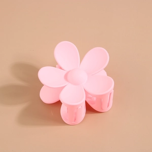 Détail d'une pince à cheveux fleur rose mate avec un design floral élégant à six pétales