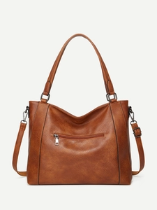 Detail showing the brown vintage distressed leather texture and stitching of this handbag