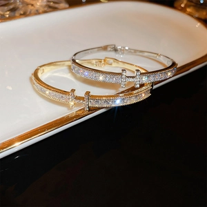 Détail macro du bracelet en forme de H avec pierres en zircon plaqué or et argent