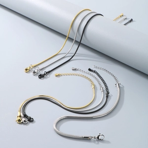 Macro view of gold, silver, and black snake bone chains with lobster clasps and extenders
