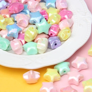 Macro shot of colorful star-shaped iridescent acrylic beads on a white relief plate