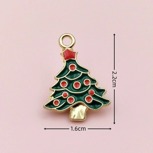 Detailed view of enamel Christmas tree charm with dimensions 2.2cm by 1.6cm on pink backdrop