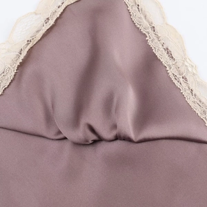 Detail of delicate beige lace trim on glossy mauve satin midi dress for women