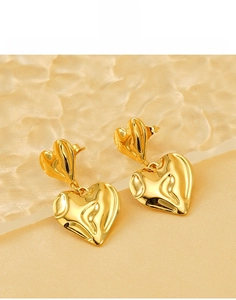 Détail de boucles d'oreilles double cœur en acier titane plaqué or 18 carats poli