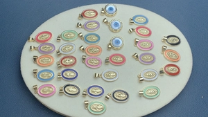 Macro shot of colorful enamel Virgin Mary and Evil Eye pendants in gold finish