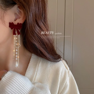 Elegante Ohrringe mit Samtschleife und Perlenquasten an einem Model im Vintage-Stil
