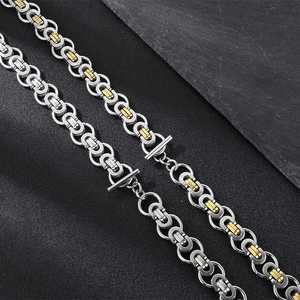 Macro detail of two-tone Byzantine chain necklaces in silver and gold with toggle clasps