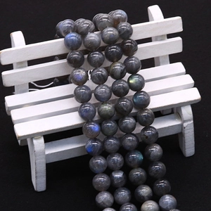 Polished natural labradorite beads with blue flash on a decorative miniature bench
