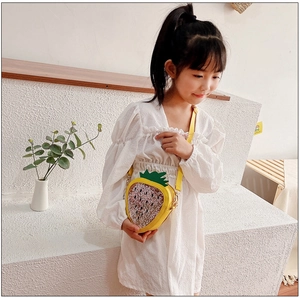 Detail of a yellow strawberry-shaped girls crossbody bag with sparkling sequins and glitter