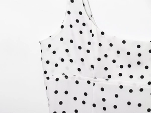 Détail d'une robe blanche à pois montrant les coutures de qualité et la texture en mousseline
