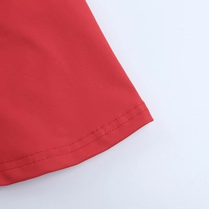 Détail de la robe rouge montrant les coutures doubles et la texture du tissu tricoté