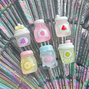 Macro detail of miniature resin fruit jars with glitter finish on holographic background