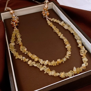 Detailed macro view of double-layer yellow gemstone beaded necklace in jewelry gift box